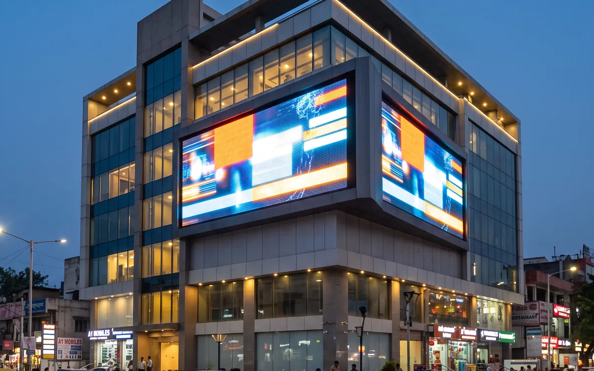 Illuminated LED sign board on a commercial building facade at dusk